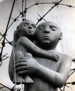פסל בטכניקת גילוף עץ, אב מחזיק את בנו על ידיו