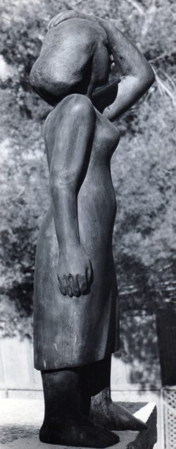 פסל בטכניקת גילוף בעץ, אישה עומדת עם יד שמאל על ראשה